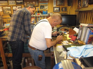Jeff Ault observing Bob Munden in shop.